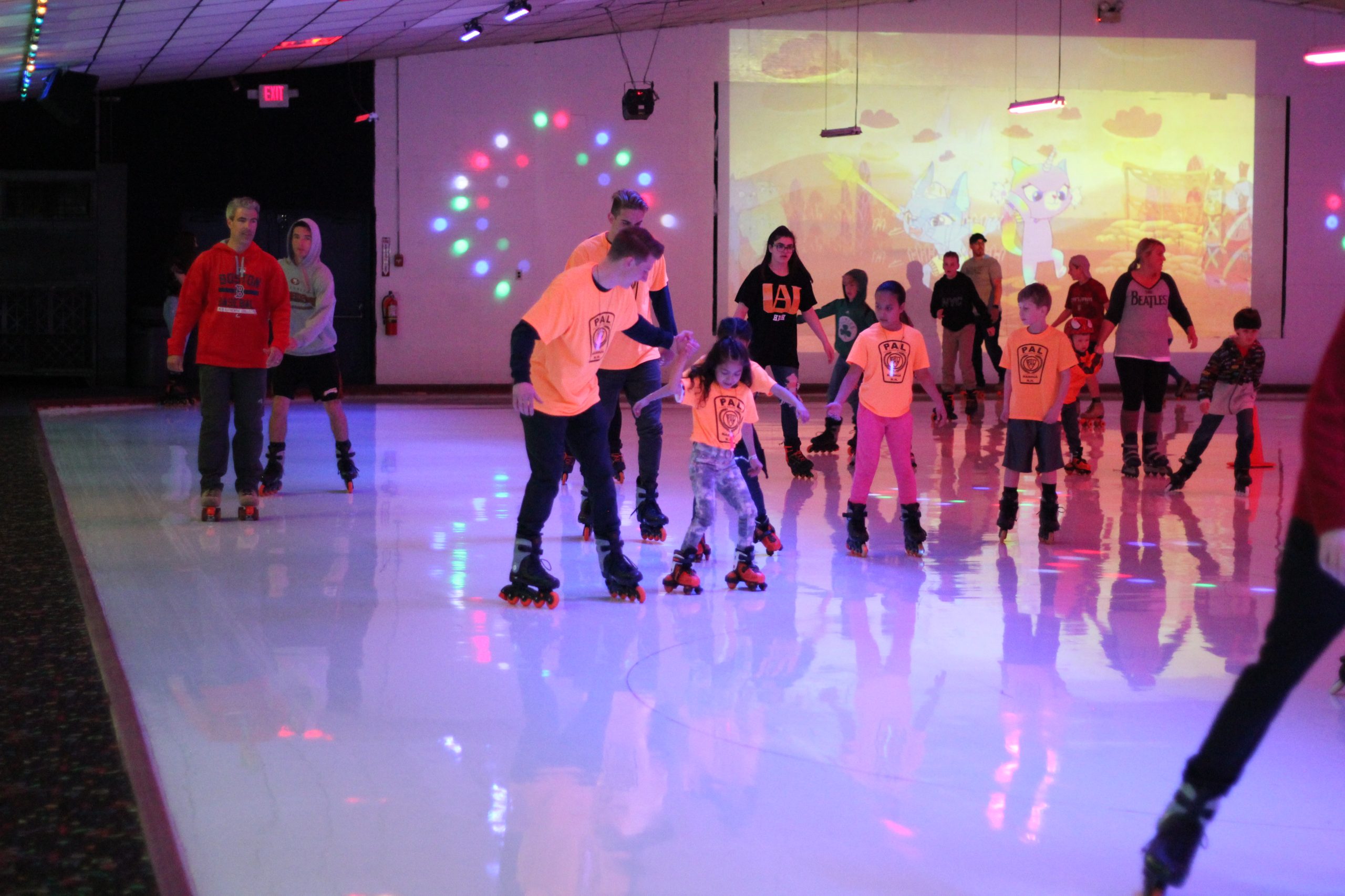 Recreational group enjoying a summer camp field trip, roller skating at Roller Kingdom under the supervision of their group leader.